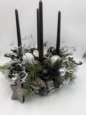 Adventskranz mit vier schwarzen Stabkerzen, weißen und silbernen Kugeln, Kiefernzweigen und Holzstern