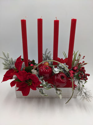 Adventsgesteck im weißen Holzkasten mit vier roten Stabkerzen, roten Äpfeln, Weihnachtssternen und Beeren