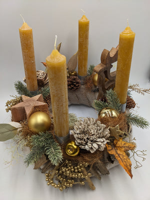 Adventskranz von oben: runder Holzkranz mit vier senfgelben Kerzen, goldenem Apfel, Holzsternen und Tannenzweigen