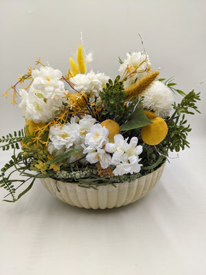 Sommergesteck mit weißen Kirschblüten, gelben Zitronen und Gräsern in cremefarbener Schale, frontal