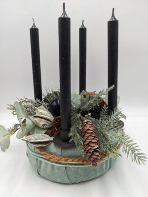 Adventskranz in mintgrüner Schale mit vier schwarzen Stabkerzen, Zapfen, Eukalyptus und Tannenzweigen