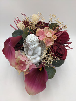 Herzförmiges Trauergesteck von oben: Engel, rosa Hortensien, Banksie und Eukalyptus