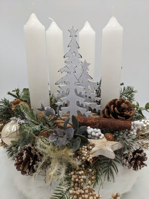 Nahaufnahme des Adventskranzes mit grauem Holzbaum, Zimtstange, Walnuss, Eukalyptus und Holzstern
