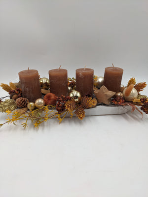 Adventsgesteck von schräg oben: vier braune Stumpenkerzen, Holzstern, Beeren und gelbe Zweige im Tablett