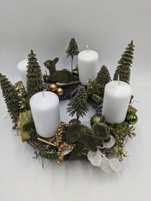 Adventskranz von oben mit vier weißen Stumpenkerzen, zwei grünen Rehkitzen, grünen und goldenen Kugeln