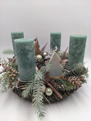 Adventskranz mit vier grünen Stumpenkerzen, cremefarbenen Kugeln, Zapfen und Holztannenbaum auf Zweigkranz