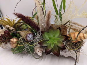 Maritimes Gesteck von der Seite mit grüner Sukkulente, Muscheln, Kupferschnecke und Federgräsern