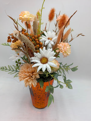 Sommergesteck mit weißen Margeriten, apricotfarbenen Blüten, orangen Beeren und Gräsern in oranger Vase