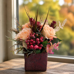 Szene Herbstgesteck Rosen Beeren Gräser apricot rot im Topf