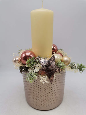 Weihnachtsgesteck im punktierten Topf mit cremefarbener Stumpenkerze, rosa Kugeln und Kupferstern