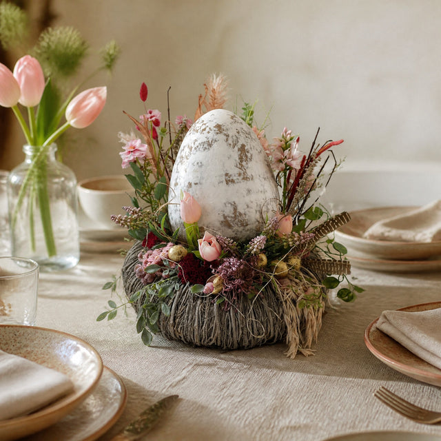 Ostergesteck mit Ei im Nest auf dem Ostertisch