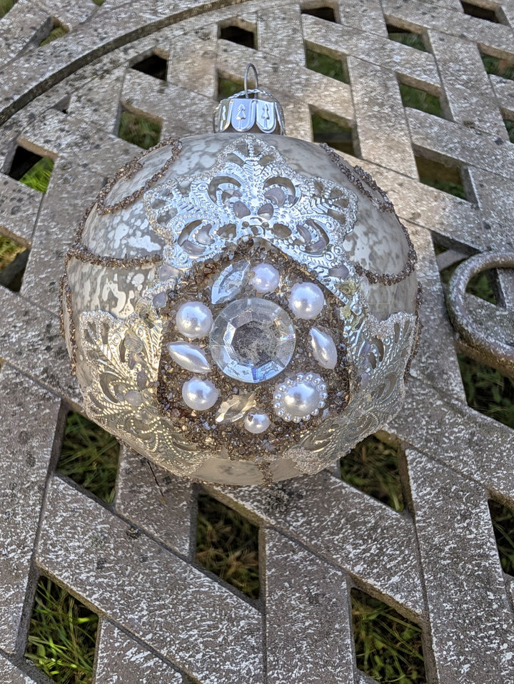 Weihnachtskugel silber creme mit Perlenkranz, Strass und silberfarbener Aufhängekappe von oben fotografiert