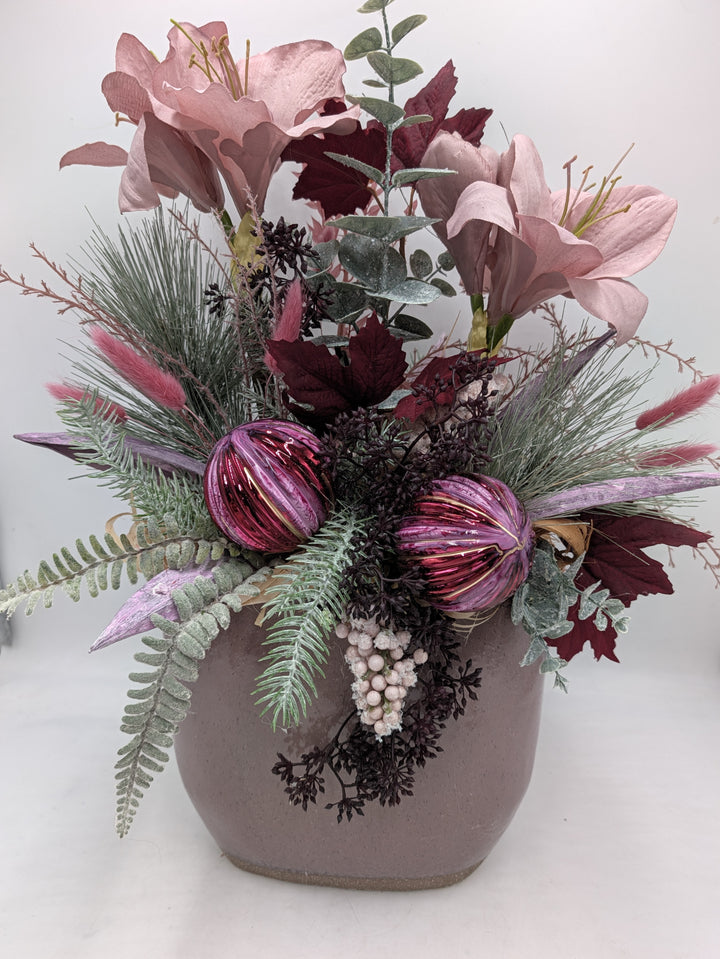 Hohes Wintergesteck mit rosa Amaryllis, pinken Kugeln, Kiefer und Eukalyptus in eckigem rosa Keramikgefäß