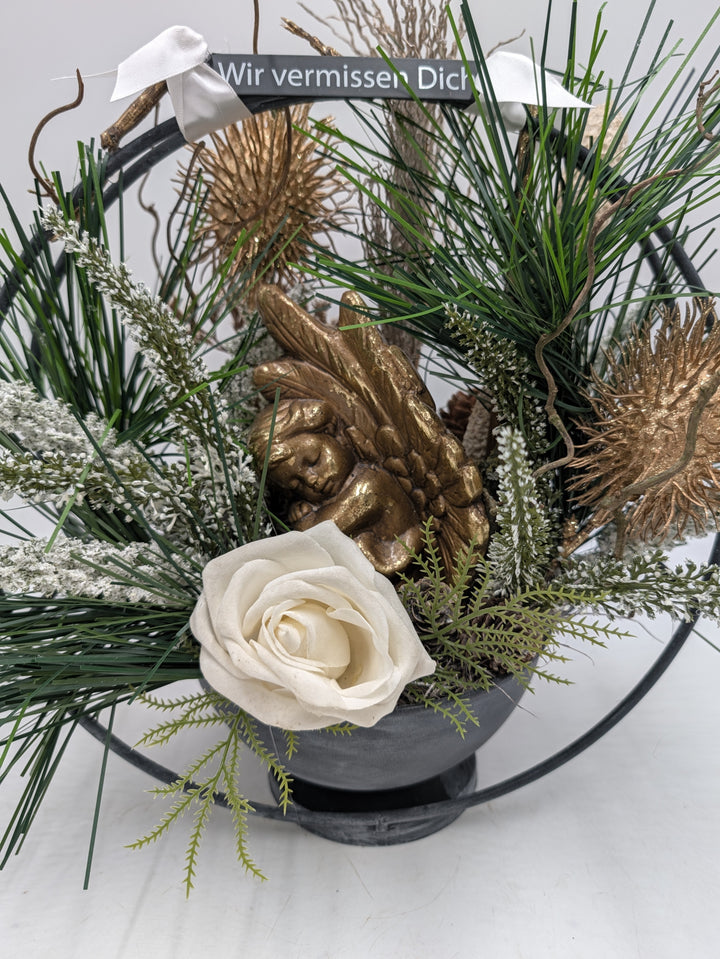 Nahaufnahme des goldenen Engels mit cremeweißer Rose, weiß gefrosteter Heide und goldenen Distelblüten