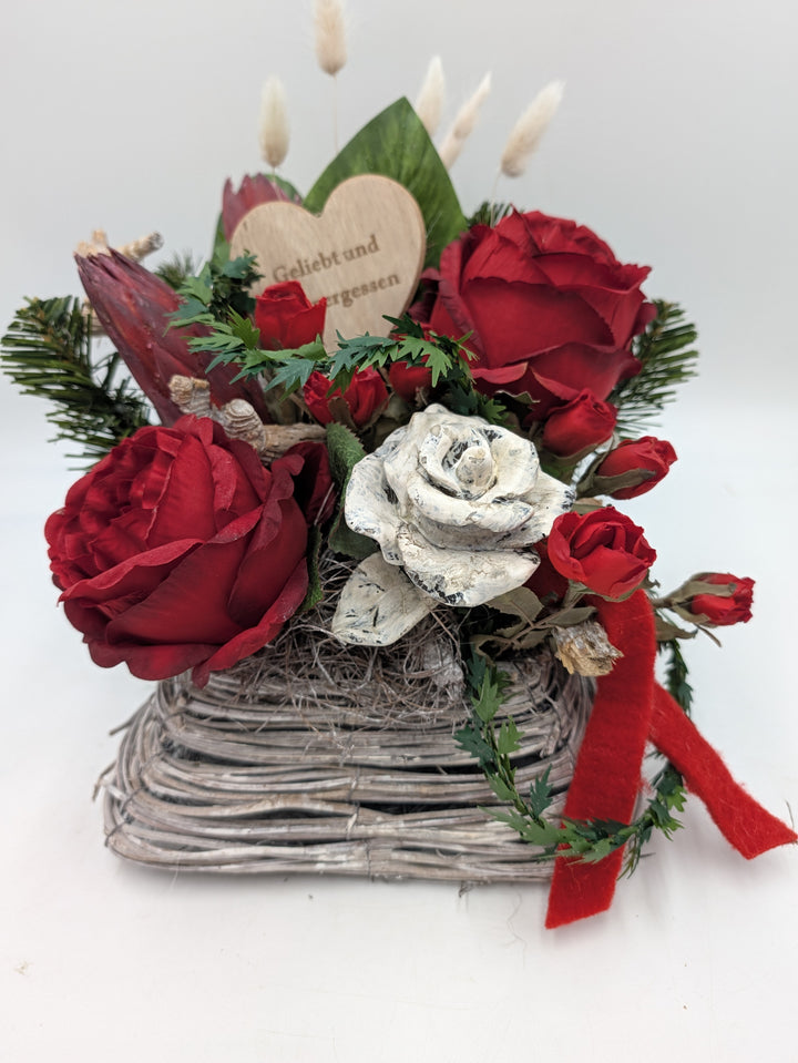 Trauergesteck mit roten Rosen, weißer Steinrose und Holzherz in eckigem Korb, rotes Filzband seitlich