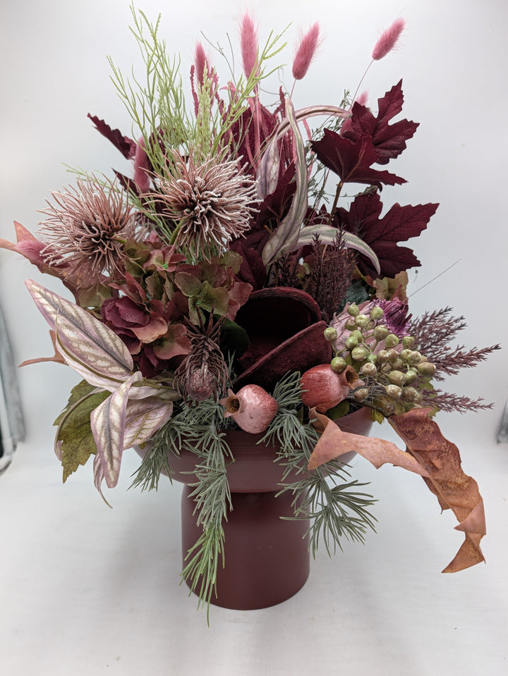Herbstgesteck in Dunkelrot und Altrosa mit Hortensien, Disteln, Ahornblättern und rosa Gräsern in Keramikvase