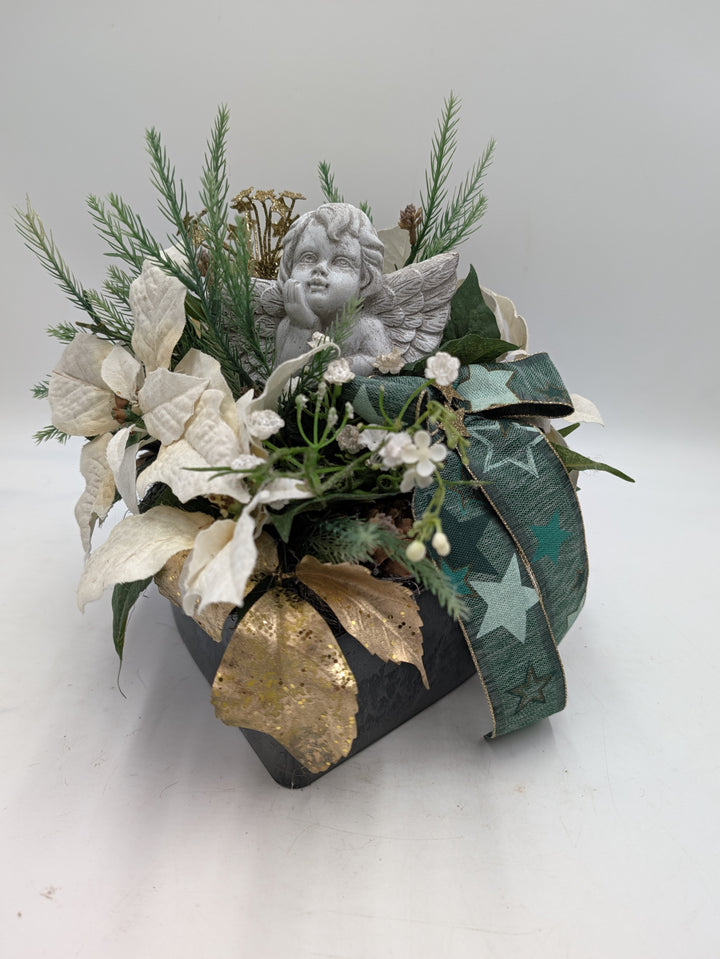 Trauergesteck mit grauem Engel, cremefarbenen Weihnachtssternen, Tannenzweigen und grüner Sternenschleife
