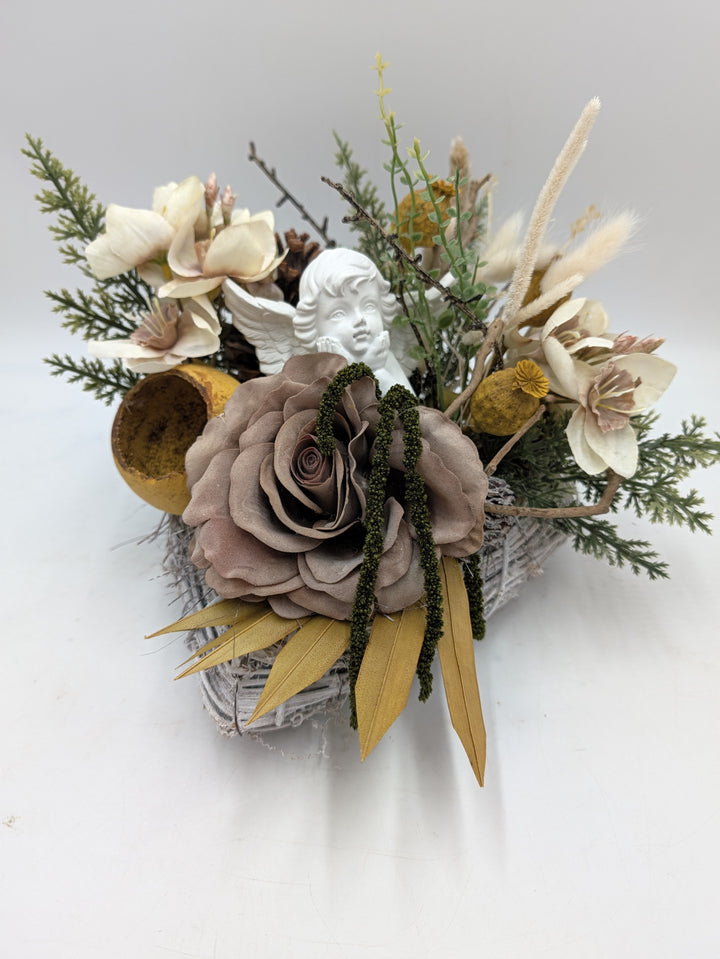 Trauergesteck mit weißem Engel, taupefarbener Rose, cremefarbenen Amaryllisblüten und gelben Blättern von oben