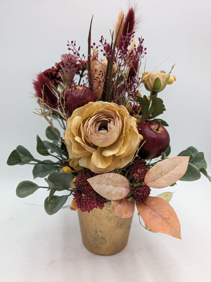 Herbstgesteck von vorn: beige Rose, bordeauxrotes Sedum, Eukalyptus und apricotfarbene Blätter