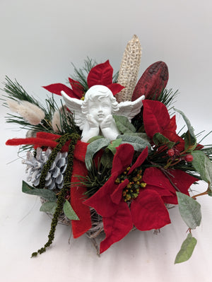 Grabgesteck mit weißer Engelfigur, roten Weihnachtssternen, Kiefernzweigen und hellen Trockengräsern