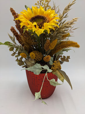Herbstgesteck mit gelber Sonnenblume, Weizen, Gräsern und Eukalyptus in rotem geriffeltem Topf