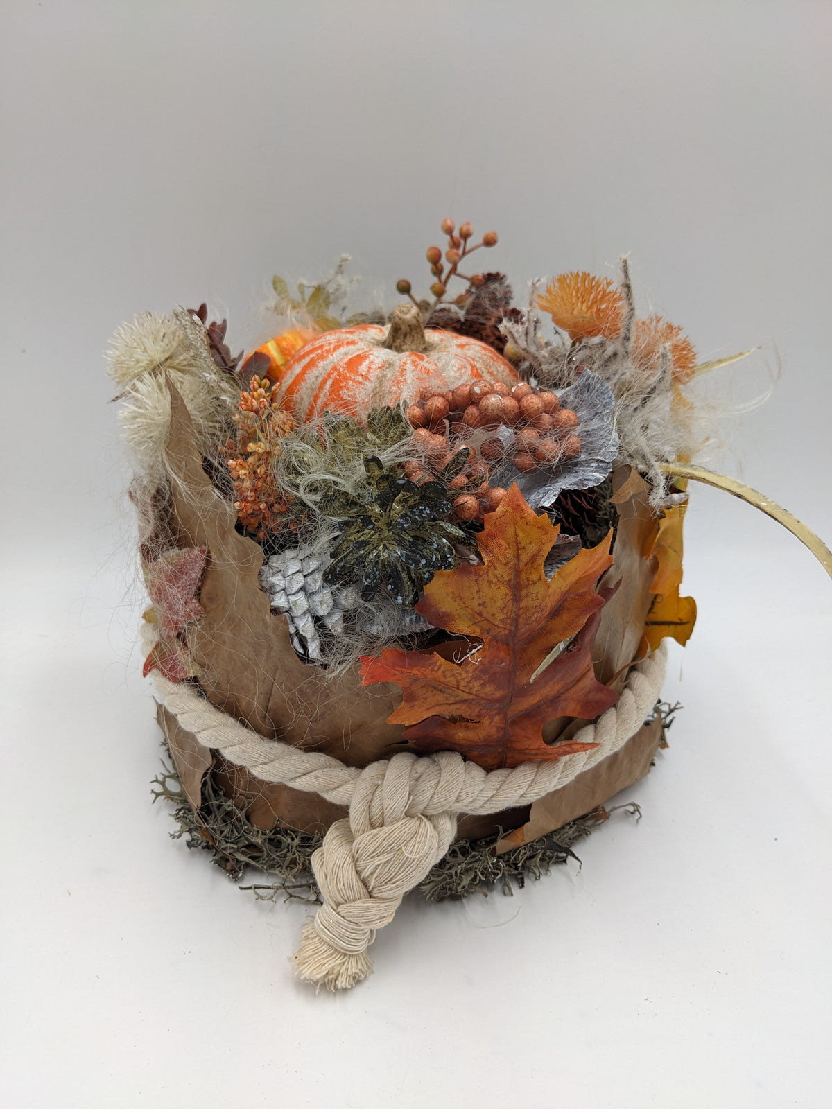Herbstgesteck von der Seite: Blätterschale mit Seilknoten, orange gestreifter Kürbis, Ahornlaub und Beeren