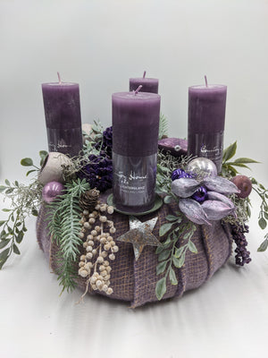Adventskranz in Lila mit vier violetten Stumpenkerzen, Kugeln, Glitterzapfen, Silberstern und mintgrünen Zweigen