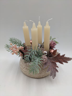 Adventsgesteck mit vier cremefarbenen Kerzen, rosa Beeren, Holzstern und Tannenzweigen in heller Keramikschale