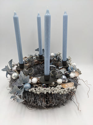 Adventskranz aus Geäst mit vier hellblauen Stabkerzen, silbernen Kugeln, Stern und Efeu, von vorne
