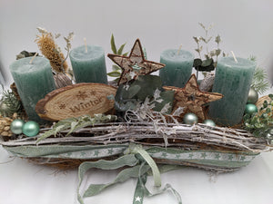Adventsgesteck aus hellem Reisig mit mintgrünen Kerzen, Eukalyptus, Ilex und mintfarbenen Kugeln, Bänder mit Sternen