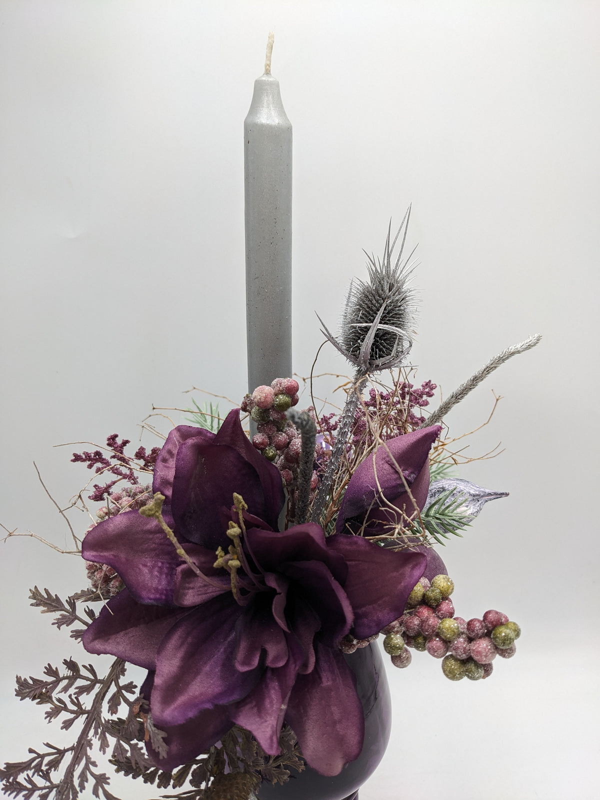 Nahaufnahme der lila Amaryllis mit silbriger Distel, zuckrigen Beeren und grauer Stabkerze