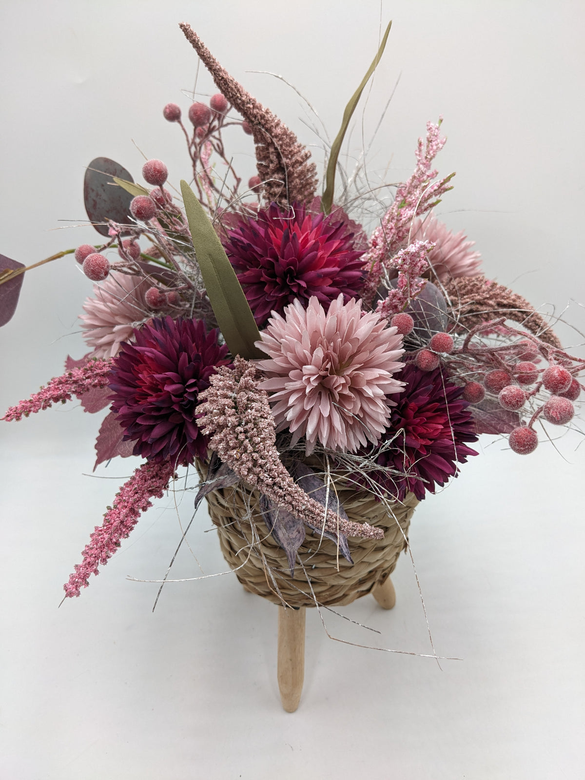 Blick von oben auf Chrysanthemen in Altrosa und Beerenlila mit rosa Rispen, Beeren und Eukalyptusblättern