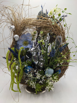 Ostergesteck im Zweigkranz mit silbernem Hasen, blauen Ostereiern, Hyazinthen und Gräsern auf Metallfuß