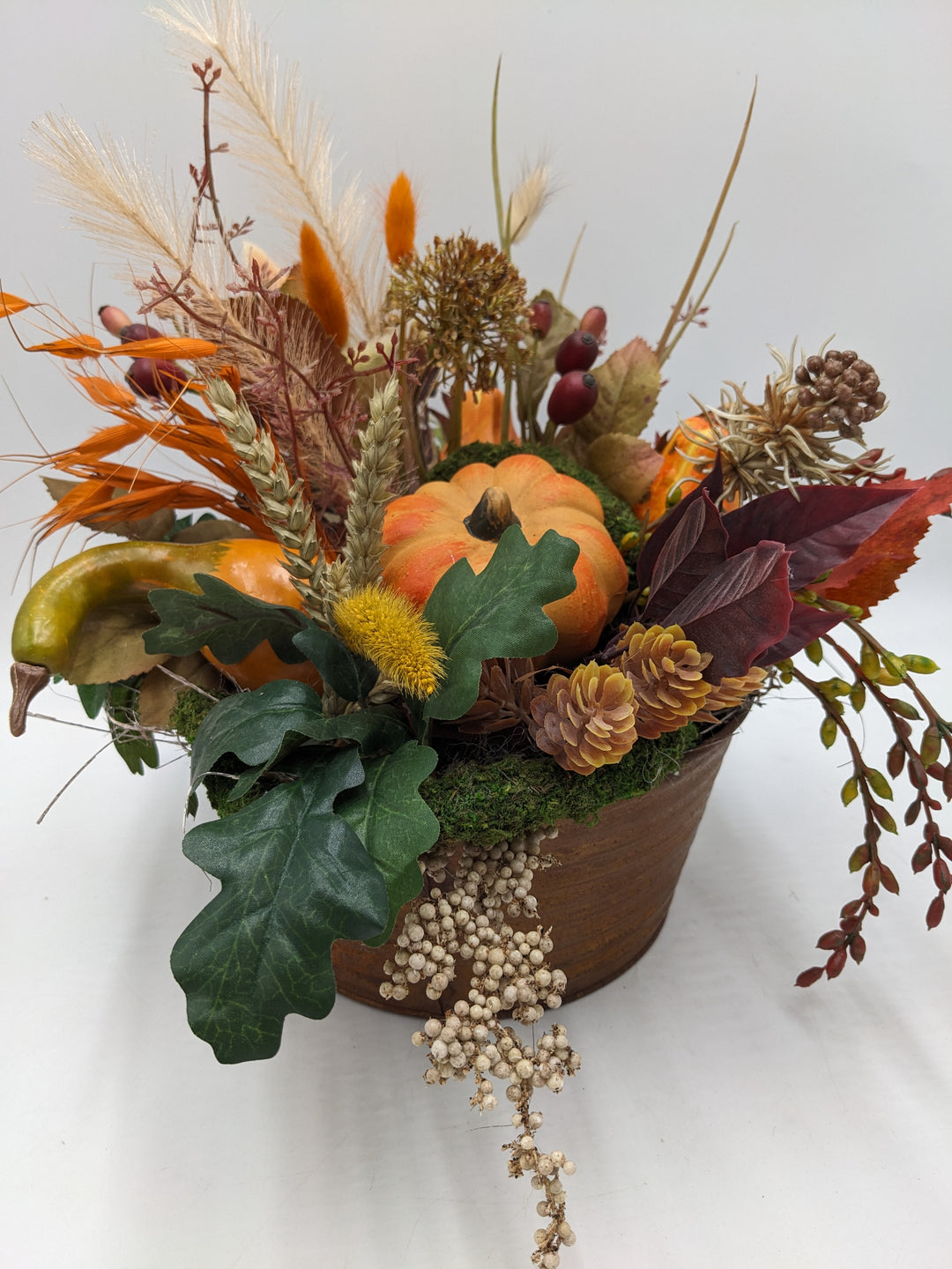 Herbstgesteck Kürbis Zapfen Feder orange