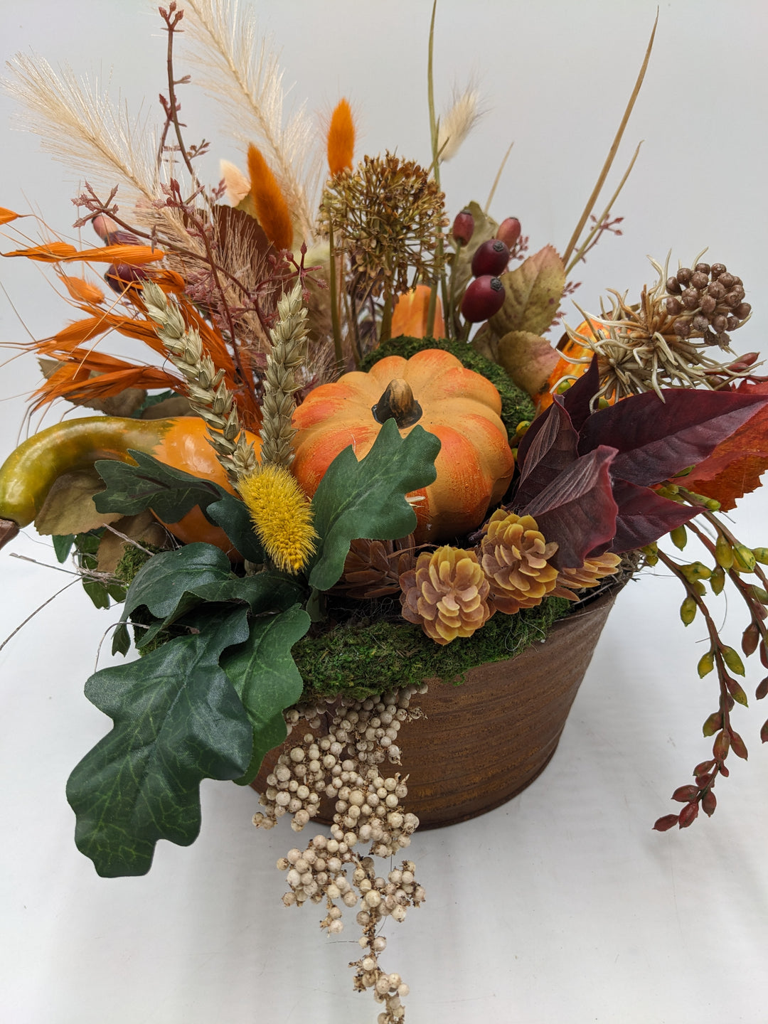 Herbstgesteck Kürbis Zapfen Feder orange
