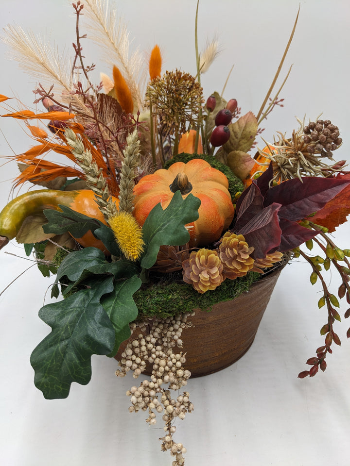 Herbstgesteck Kürbis Zapfen Feder orange