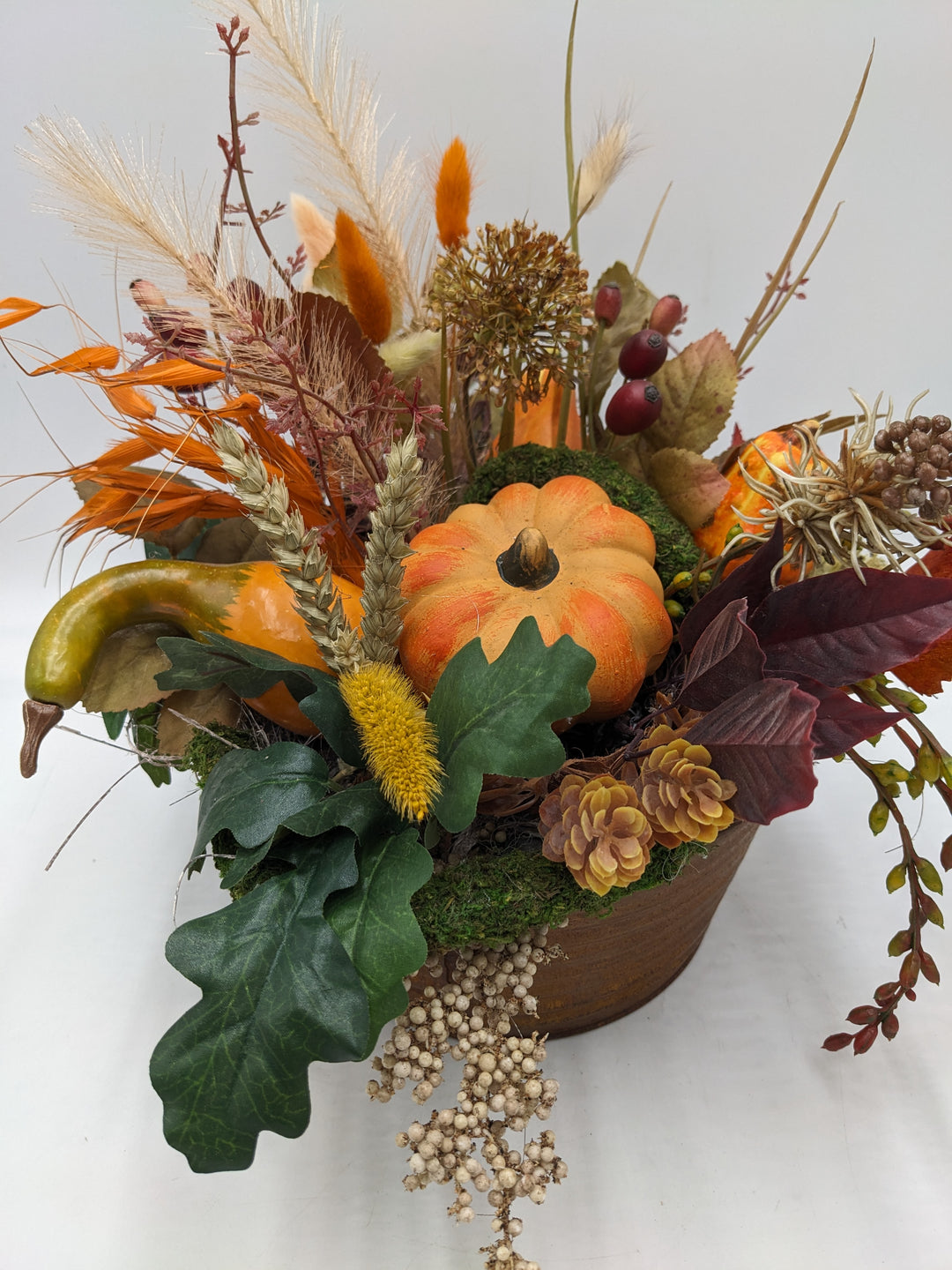 Herbstgesteck Kürbis Zapfen Feder orange
