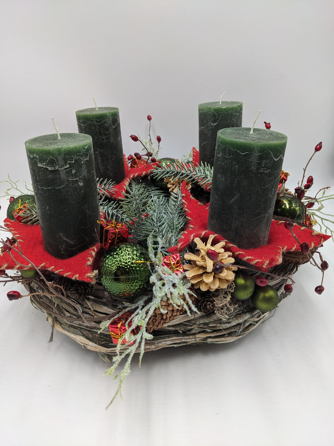Adventskranz dunkelgrün rot mit Kerzen Sternen Kugeln Zapfen