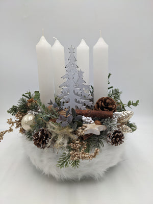 Adventskranz in Weiß und Creme mit vier weißen Stabkerzen, Holzbaum, Zapfen und Beeren auf weißem Fellsockel