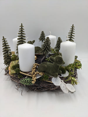 Adventskranz aus Zweigen mit vier weißen Kerzen, grünen Tannenbäumchen, Rehkitz und goldenen Beeren