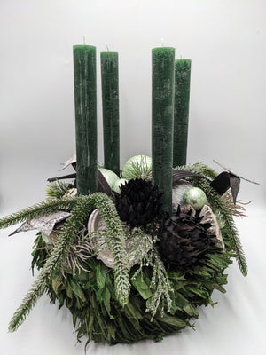 Adventskranz in Grün mit vier dunkelgrünen Stabkerzen, hellgrünen Kugeln, schwarzen Artischocken und Silbersternen