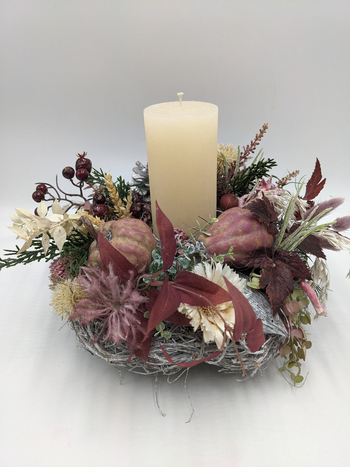 Herbstgesteck von schräg oben: Kerze in der Mitte, Zierkürbisse, Strohblumen, Gräser und Tannenzweige