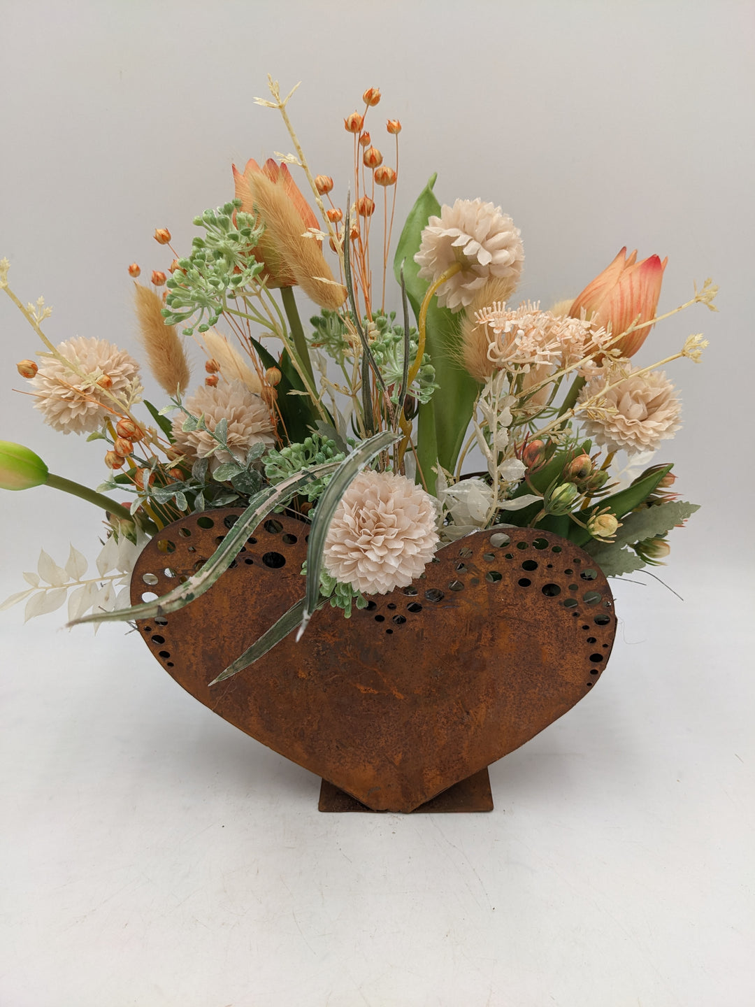 Frühlingsgesteck Herz Tulpen Gräser apricote