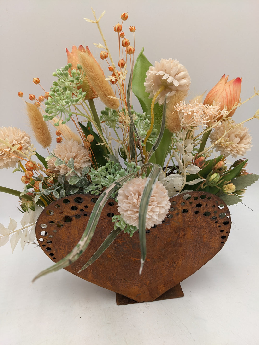 Frühlingsgesteck Herz Tulpen Gräser apricote