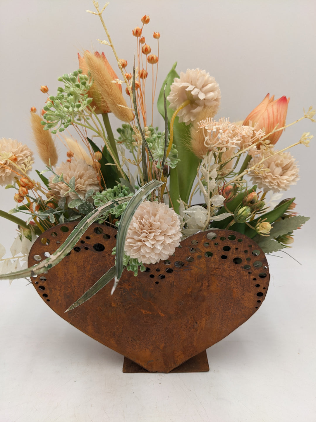 Frühlingsgesteck Herz Tulpen Gräser apricote