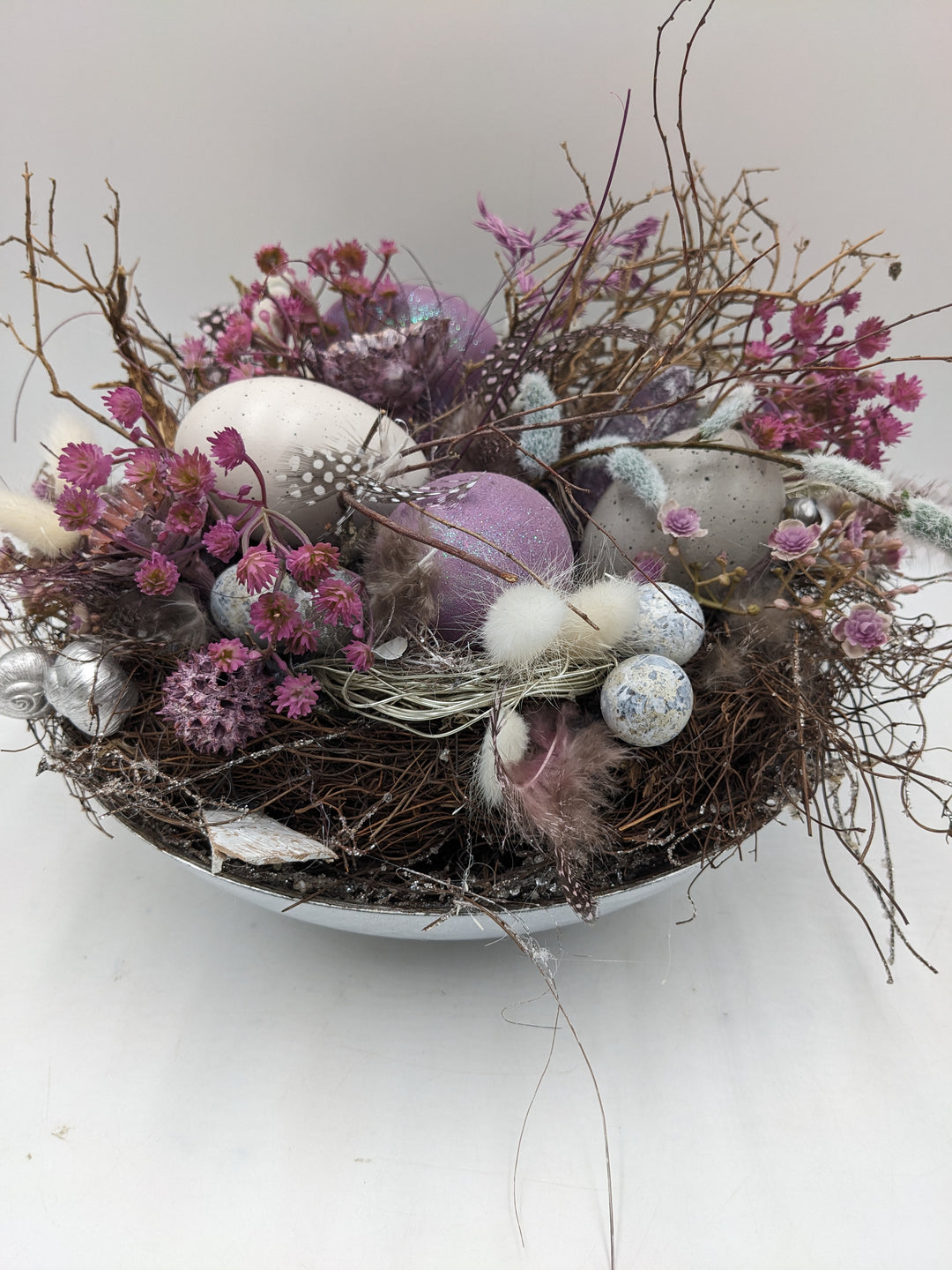 Ostergesteck Frühlingsgesteck Nest Federn Kätzchen lila