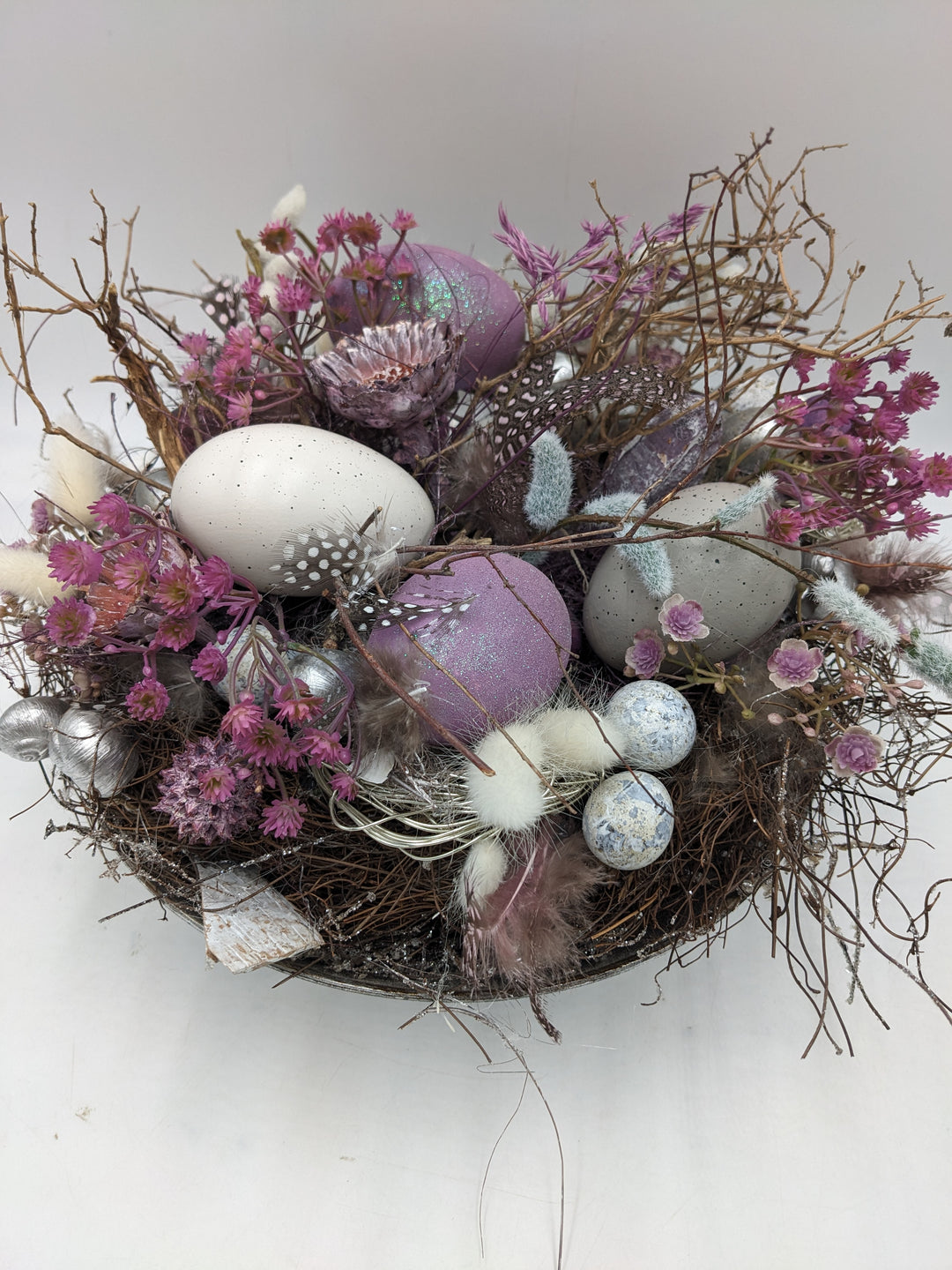 Ostergesteck Frühlingsgesteck Nest Federn Kätzchen lila