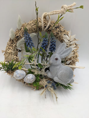 Osterkranz mit Kordelaufhängung, blauen Muscari-Blüten, grauem Hasen und Ostereiern in Grau und Creme