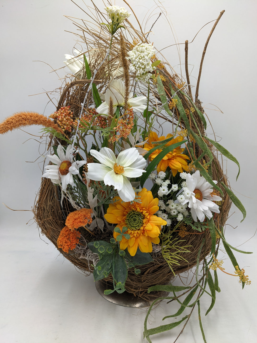 Frühlingsgesteck Margeriten Gräser orange weiss