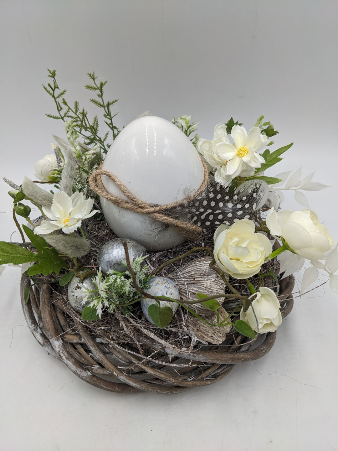 Ostergesteck Frühlingsgesteck Ranunkel Ei Feder weiss